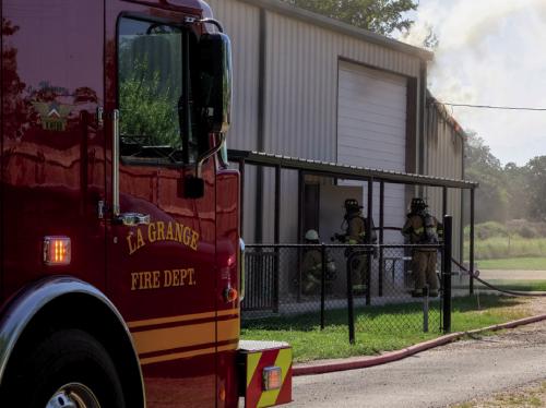 La Grange volunteer firefighters prepare the enter the burning pottery workshop at Gray Legacy Services on Monday, July 20. Photo by Andy Behlen