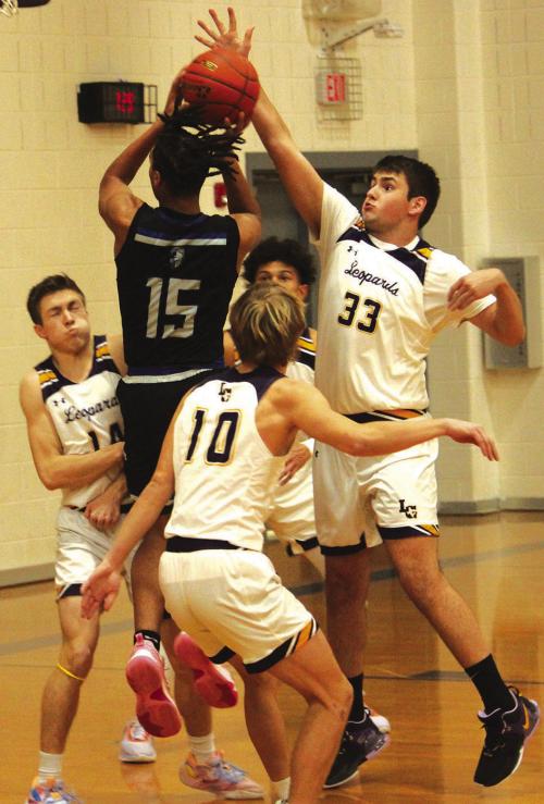 La Grange’s Clayton Knapik, left, takes a charge as teammate Reece Nygren, right, blocks a Manor shot Friday. Photo by Jeff Wick