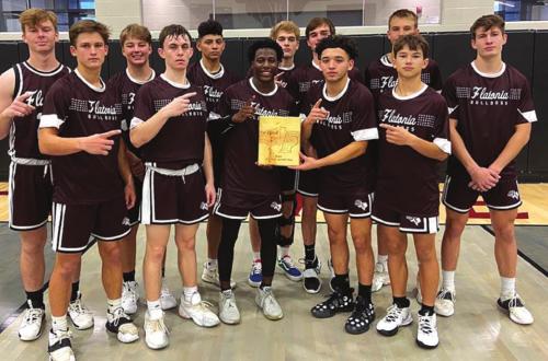 The members of the Flatonia Bulldogs varsity basketball team hold up their championship trophy after winning the Fayetteville Tournament Saturday.