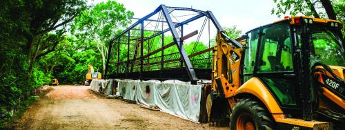 In this photo from April of 2025, the Willow Springs Bridge sits on the south bank of Cummins Creek while contractors build new concrete approaches. Then-Pct. 2 Commissioner Luke Sternadel said it took a 100-ton crane to pick up and move the bridge. The bridge itself does not weigh that much, but it took such a large piece of machinery due to the tricky nature of navigating the creek-bottom terrain. Record file photo by Andy Behlen