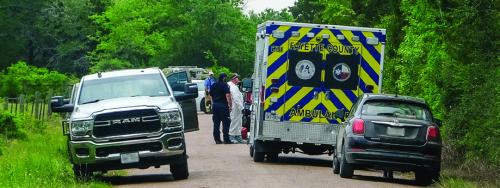 First responders, including some wearing white haz-mat suits, gather around the spot on Coufal Rd. where a body was discovered on Tuesday, April 15. Photo by Andy Behlen