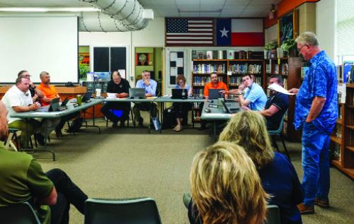 Richard Hoogendoorn, standing at right, addresses the Schulenburg I.S.D. Board of Trustees about his reassignment Monday evening, May 19. Photo by Andy Behlen