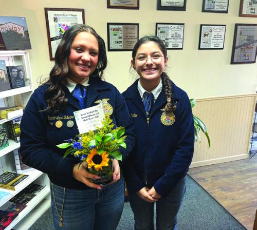 Weimer High School students Gracie Ribeiro, left, and Kimberly Rubio, right, stopped by The Fayette County Record newspaper office Friday to drop off a flower arrangement they made in their floral design class at school and to remind folks about the annual Weimar FFA Stock Show Friday Feb. 14 beginning at 8 a.m. and the sale the following day, Feb. 15 at 2:30 p.m.