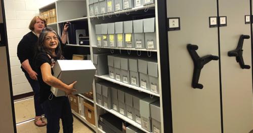 Archivists Rox Ann Johnson and Maria Rocha (front) organizing the new shelving.