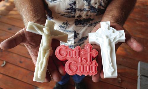 Doug Janda holds a trio of items made from the powdered marble of the old altar at the Queen of the Holy Rosary Church, which was destroyed by fire on June 9, 2022. Photo by Jessica Montez