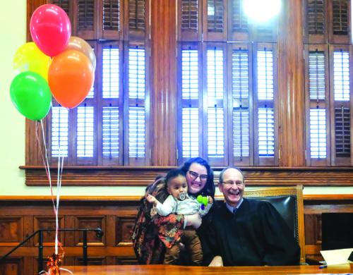 District Judge Jeff Steinhauser (right) posed for a photo with Cheyenne Evans and her newly-adopted son, Jaxon, following the adoption proceeding in court last Tuesday. Photo by Andy Behlen
