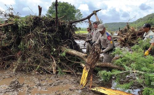 In this photo courtesy of the Texas Department of Public Safety, officers work to clear some of the massive debris fields from the July 4 storm in Kerr County.