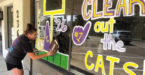 Carrie Harbers was out painting the Clear Title Company window on the courthouse square Tuesday afternoon for homecoming, which is Oct. 9. Photo by Jeff Wick