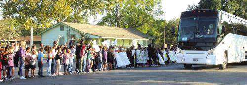 La Grange elementary students line Milam Street with signs as the charter buses carried the band members to the Alamodome for the state marching contest Wednesday. Photo by Jeff Wick