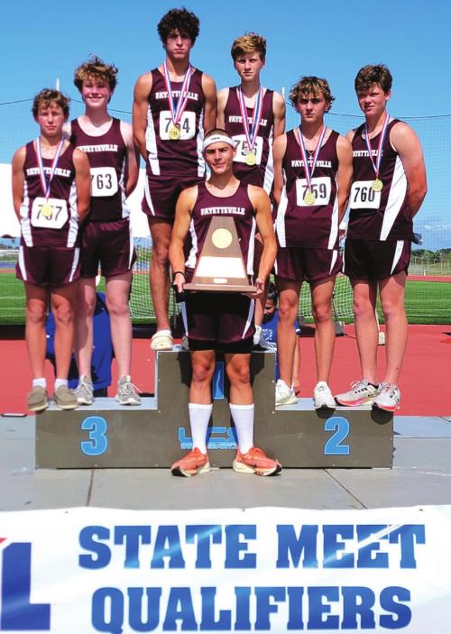 The Fayetteville boys cross country team holds up their regional championship trophy after winning the title Monday in Corpus Christi.