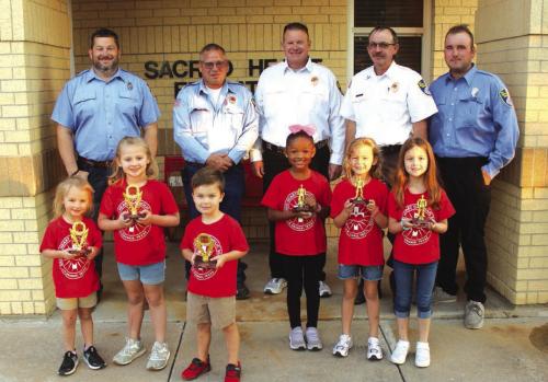 Pre-K and Kindergarten Division – Left to right, Winners: Adelyn Montgomery, Sami Montgomery, D.J. Wick; Honorable mention – Adelunn Brown, Heidi Gaertner, Rylee Mozisek. Back row: La Grange firefighters Chris Kaspar, Kenneth Chovanec, Todd Johnson, Glen Knigge, and Blythe Vitek. Photo by Jeff Wick