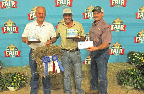 Dennis Brower won Grand Champion at The Fayette County Fair Hay Show Thursday. He is shown here, left, with his hay. Center is Matt Arthur of Bumper Crop Texas, who bought the hay for $1,900. Right is Mark Vecera representing Farmers Coop in Schulenburg, which donated 1,000 pounds of fertilizer to the winner. Vecera is also the Chairman of The Schulenburg Young Farmers, which sponsored the hay show. Photos by Jeff Wick