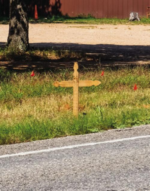 A wooden cross now marks the spot where Bradley Votaw, 43 of La Grange, died in a motorcycle crash near Post Oak Inn on FM 155 last Tuesday. Photo by Andy Behlen