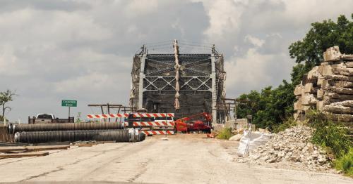 Folks in La Grange got their first glimpse in months of the old river bridge across the Colorado River on Travis St. Workers recently removed a big section of the giant tarp that has been covering it while paint work was underway. Photo by Andy Behlen