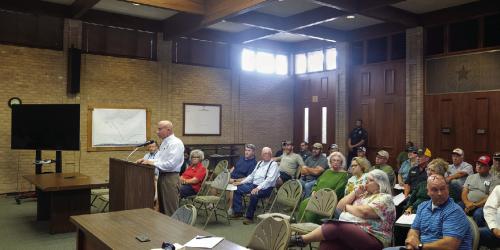 Local architect Brad Cutright, pictured speaking at the podium during Monday night’s La Grange City Council meeting, was among seven local business people and building contractors who pleaded with the City Council to hire an in-house building official. They complained of increased costs, delays and communication problems ever since the City outsourced the permitting and inspection process. Photo by Andy Behlen