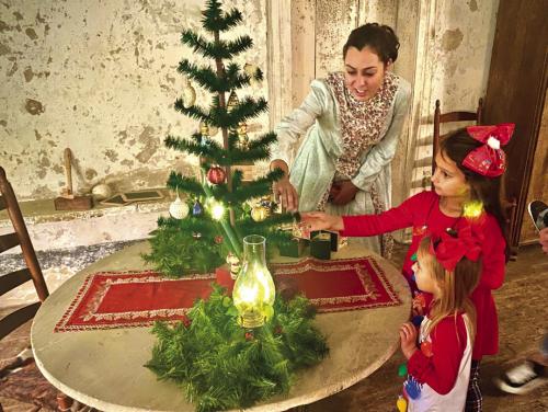 Jennifer Townzen, Lead Educator at Kreische Brewery and Monument Hill State Historic Sites, shows off a traditional Christmas Tree inside the Kreische House to visitors as a previous Trail of Lights evening.