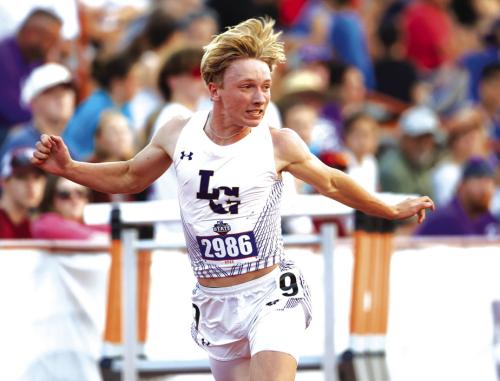La Grange’s Austen Diggs leans at the finish line as he wins the 200 meter dash.