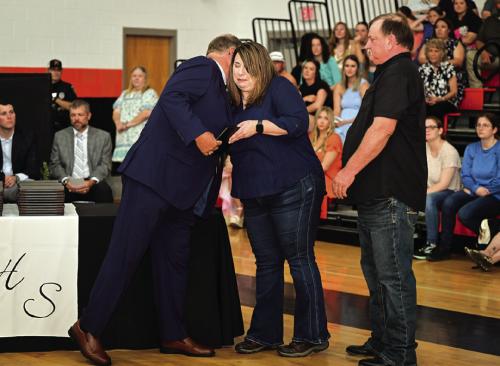 Melissa and Michael Adcox received a diploma on behalf of their son, Weston Adcox, who would have graduated with the class of 2025. Weston was a fifth grader at Schulenburg ISD when he passed away unexpectedly. School board president Mike Zweschper presented the honorary diploma to the family. Photo by Stephanie Steinhauser