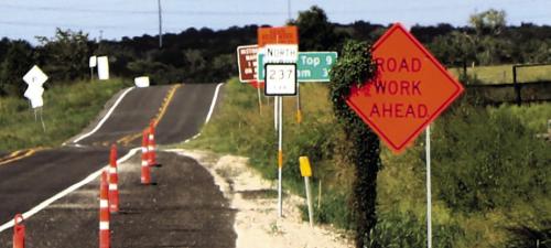 The roadwork on SH 237/159 northeast of La Grange seems like it will never end. Pretty soon, the Highway Department will need to cut these vines that are starting to overgrow their construction signs. Photo by Gary E. McKee