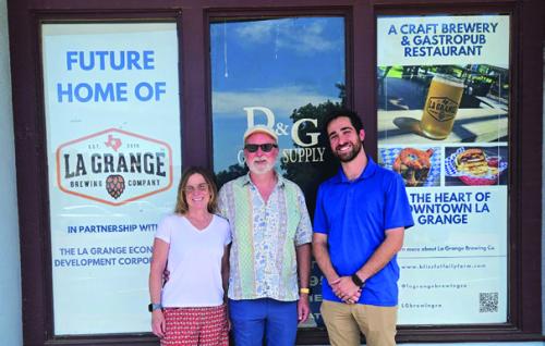 Wendy and John Rohan, left, stand with La Grange Main Street Manager Caleb Parks, right, in front of the site of the new brewery and restaurant.